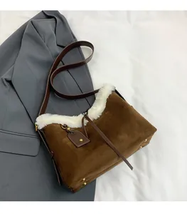 Détail du sac en daim marron avec bordure en fausse fourrure blanche et clous