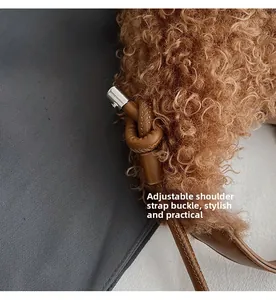 Detail of adjustable knotted leather strap on a brown plush teddy fleece handbag