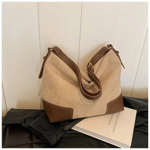Dettaglio della borsa hobo retrò in pelle scamosciata beige con finiture in pelle marrone