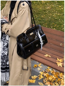 Detailed view of black glossy leather tote with pocket flaps and silk scarf handle