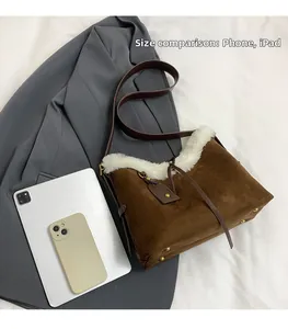 Détail du sac en daim montrant sa grande capacité face à un iPad et un téléphone