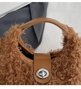 Detail of brown faux fur handbag with leather handle and silver metal swivel lock