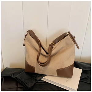 Dettaglio della borsa tote in pelle scamosciata kaki con base in cuoio marrone e fibbia oro