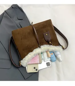 Vue détaillée du sac bandoulière en daim marron avec bordure en fourrure et grand volume