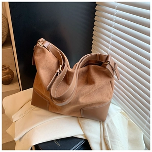 Dettaglio della borsa tote in pelle scamosciata caramello con angoli in pelle e tracolla