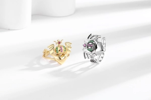 Detail of gold and silver crown rings with heart wings and colorful zircon stones