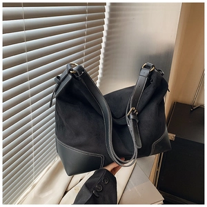 Dettaglio della borsa tote nera con cuciture a contrasto, texture opaca e finiture oro