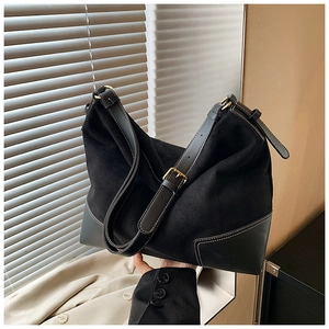 Dettaglio della borsa tote nera con cuciture a contrasto e mix di texture scamosciate