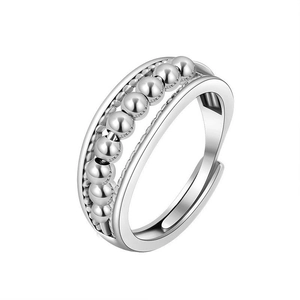 Detailed macro view of adjustable silver spinner ring with rotating beads for stress relief