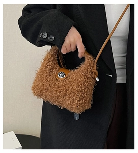 Détail du sac à main en peluche marron avec fermoir rotatif argenté et bandoulière en cuir
