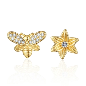 Asymmetric gold earrings featuring a crystal honeybee and sunflower on white background