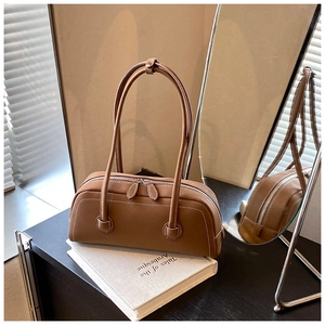Detail of brown leather Boston tote bag with white contrast stitching and silver zippers