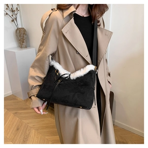 Détail du sac bandoulière en daim noir avec garniture en fausse fourrure blanche élégante