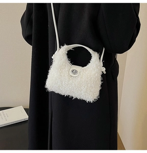 Détail d'un sac à main en peluche blanche avec fermoir rotatif argenté et poignée cuir