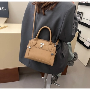 Sac bandoulière en cuir avec motif litchi et détail de cadenas argenté porté
