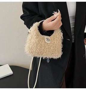 Detail of beige faux shearling dumpling bag with silver twist lock and slim strap