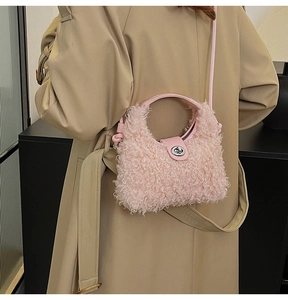 Detail of pink plush crossbody bag with leather handle and silver metal twist lock closure