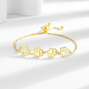 Bracelet doré ajustable avec quatre motifs de pattes évidés et chaîne vénitienne