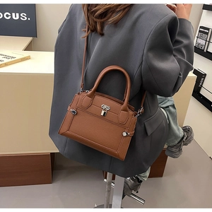 Détail du sac en cuir litchi marron foncé avec fermoir argenté et design professionnel