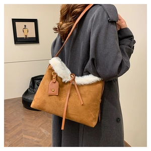 Détail d'un sac en daim marron avec bordure en fourrure blanche sur un manteau d'hiver