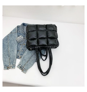 Macro detail of black quilted puffer tote bag with glossy finish and durable zipper closure