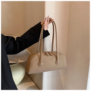 Detail view of khaki leather tote with white contrast stitching and dual zipper closure