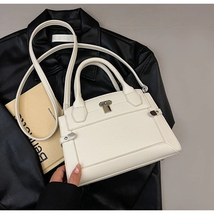 Détail du sac à main blanc en cuir grainé avec fermoir argenté et texture de qualité