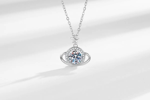 Macro detail of planet pendant necklace with brilliant moissanite and star accents