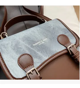 Dettaglio della borsa vintage con patchwork di pelle marrone e denim blu chiaro