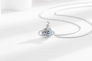 Macro shot of silver planet pendant necklace featuring sparkling circular center gemstone