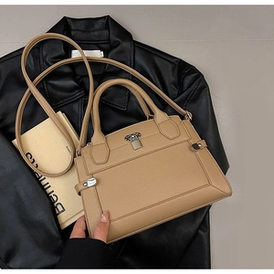 Détail du sac à main en cuir grainé camel avec fermoir rotatif et bandoulière amovible