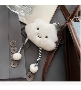 Simpatico ciondolo a nuvola in peluche bianco con ricamo su una giacca grigia