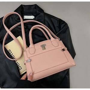 Sac à main rose en cuir grainé avec fermoir argenté et bandoulière sur cuir noir