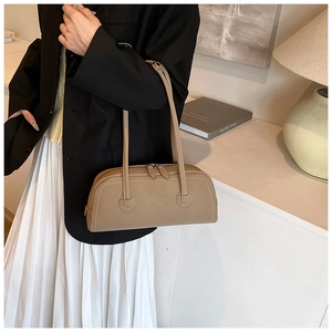 Detail of beige faux leather tote with fine stitching and dual zipper closures