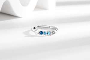Macro detail of adjustable silver star ring with gradient blue and clear zircon stones