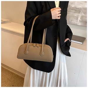 Chic retro tan leather tote bag with long handles and dual zipper detail on model