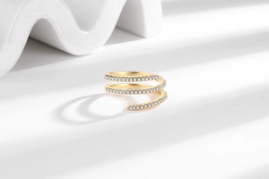 Detailed close-up of a golden spiral multi-layer ring with sparkling cubic zirconia pavé