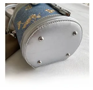 Vue détaillée du fond du sac seau en denim avec rivets de protection en argent