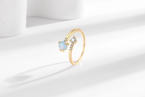 Nahaufnahme eines verstellbaren Goldrings mit Opal und Mikro-Zirkonia-Akzenten