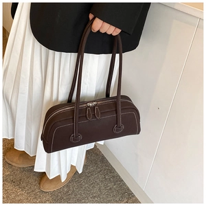 Detail of dark brown tote bag with white contrast stitching and double zipper closure