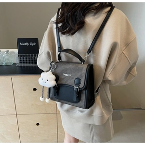 Dettaglio dello zaino alla moda grigio e nero con ciondolo a nuvola soffice