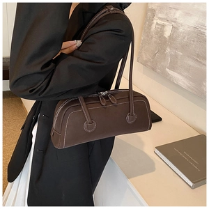Close-up of brown Boston tote bag with white contrast stitching and matte leather texture