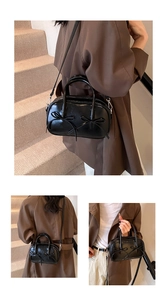 Detail of vintage black shiny shoulder bag with ribbon bows and detachable strap