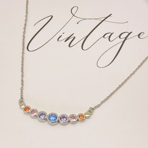 Rainbow necklace with multi-colored gemstones in a curved pendant on a silver-tone chain