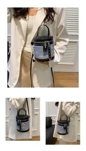Vue détaillée du sac seau en denim avec broderies dorées et finitions en cuir noir