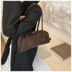Detail view of brown vintage Boston bag featuring contrast white stitching and dual zippers
