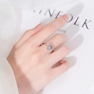 Minimalistischer silberner Ring mit blauem Opal und Zirkonia am Finger getragen