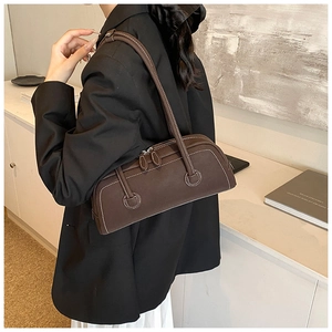 Detail of vintage brown shoulder bag showing white contrast stitching and matte leather