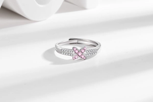Detail of silver crisscross ring with pink and white zircon stones on geometric base