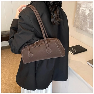 Detail of dark brown suede tote bag with white contrast stitching for autumn office wear